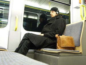 Weary man in near empty tram enjoying his trip home